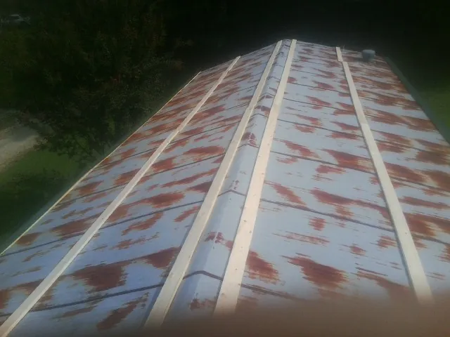 Rusted metal roof panels with new wood purlins before replacement — Storm Damage Roof Repair in Mcleod by Roofing Brothers
