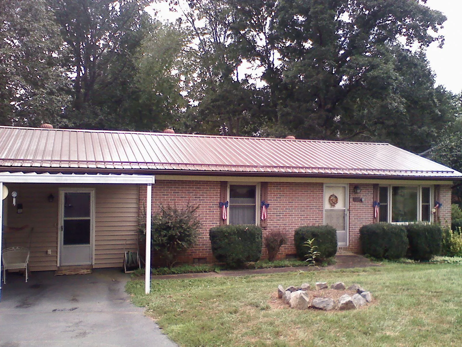 Bronze metal roof and carport on a brick ranch home — Roof Repair work by our crew in Mcleod